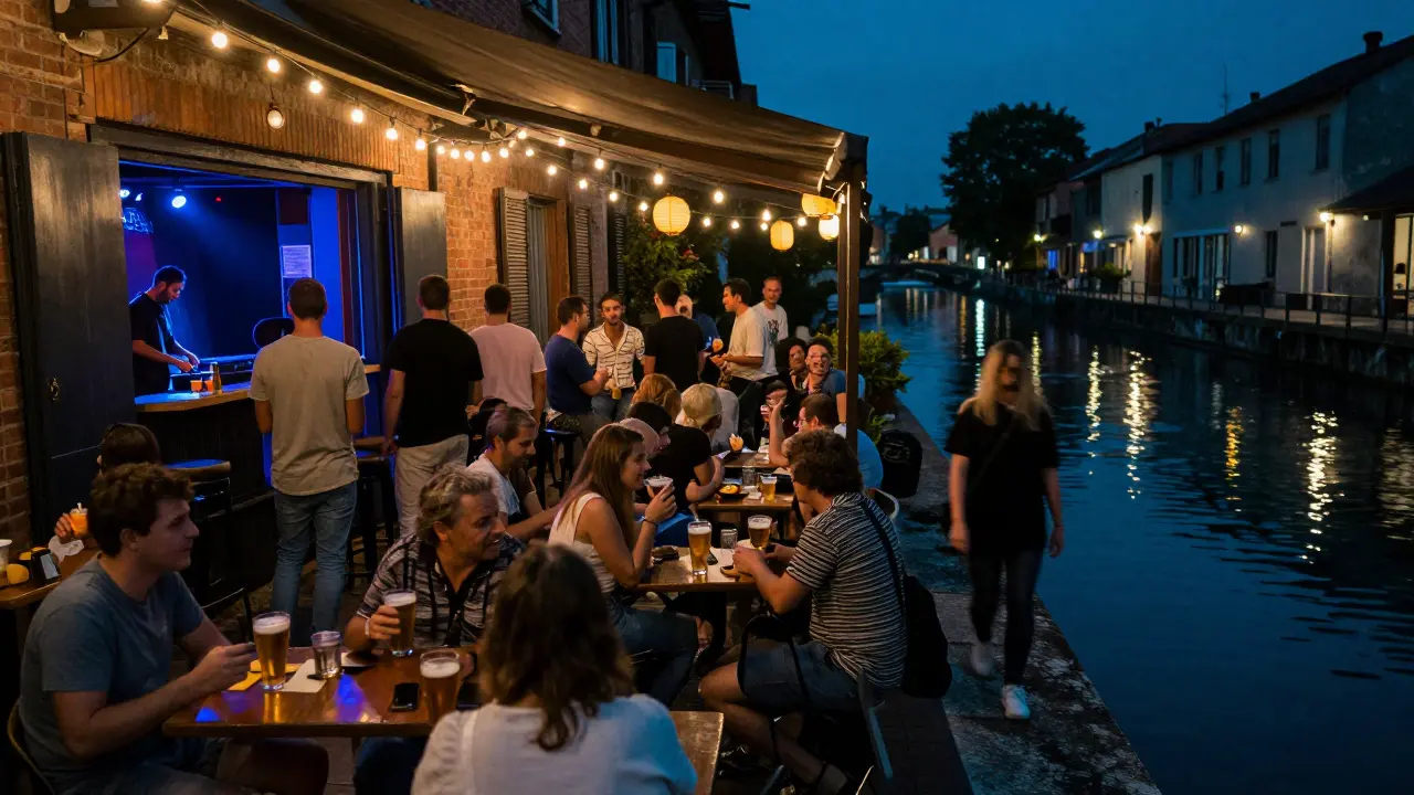 A lively canal-side terrace in Navigli with people drinking under string lights, music drifting from a nearby club.